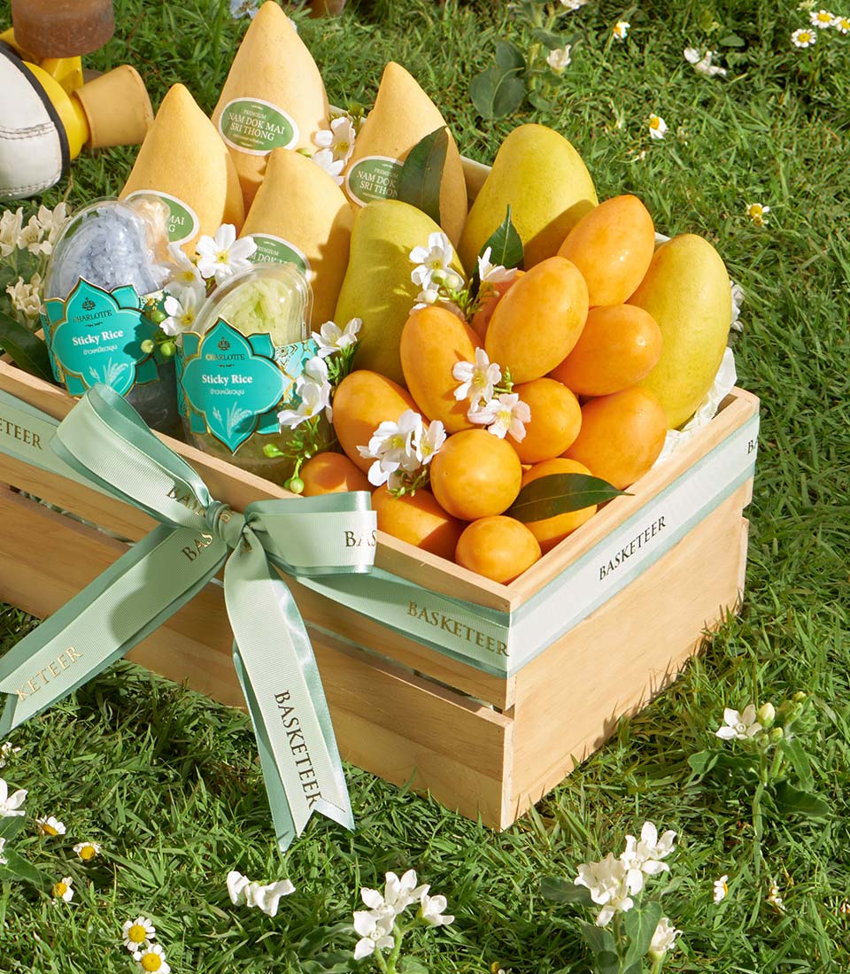 Premium mango and sticky rice wooden basket with fresh tropical fruits and green ribbon bow
