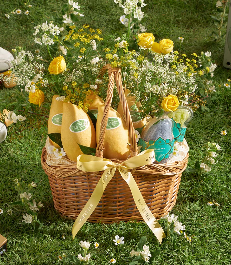 Premium Nam Dok Mai mango gift basket with fresh yellow roses and white filler flowers, yellow ribbon bow