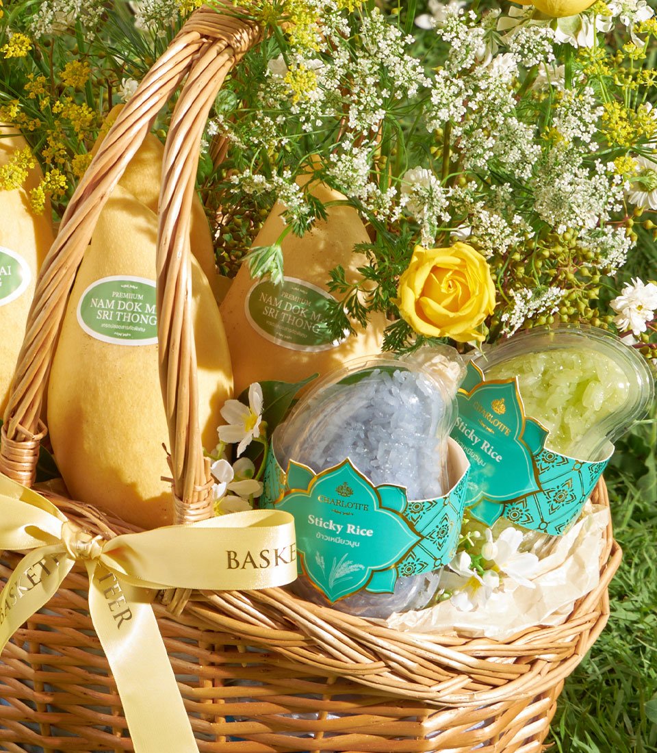 Premium Nam Dok Mai mango basket with fresh yellow roses, sticky rice, and tropical flowers in woven wicker
