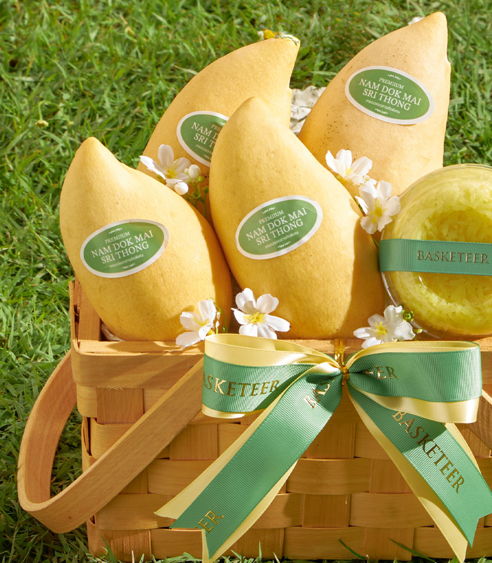 Premium Nam Dok Mai mango gift basket with sticky rice, woven with fresh yellow mangoes and artisan packaging on green