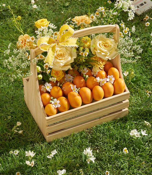 Luxury wooden crate with fresh apricots, yellow and cream roses, and white wildflowers with yellow ribbon