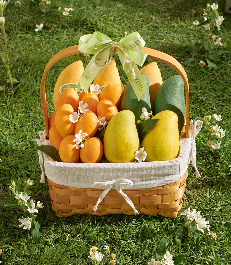 Premium Thai mango and tropical fruit gift basket with hand-woven wicker and fresh white blooms
