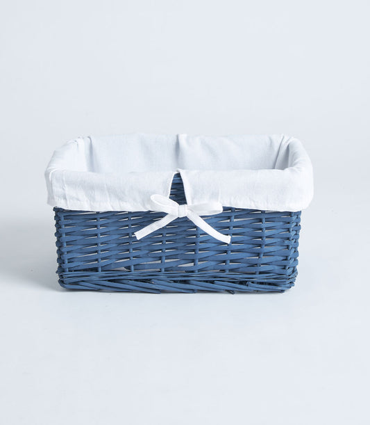 Navy wicker rectangular gift basket with white fabric lining and ribbon bow