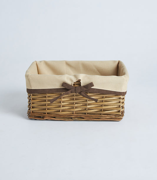 Natural woven wicker rectangular basket with beige fabric lining and brown ribbon bow