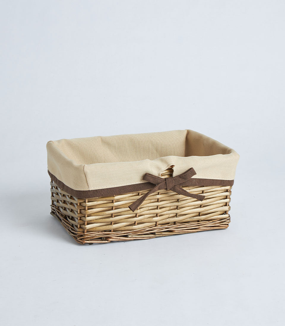 Natural wicker rectangular basket with beige fabric lining and dark brown ribbon bow