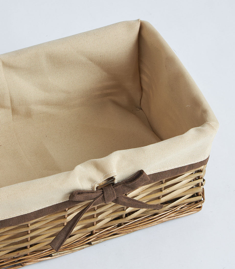 Natural wicker rectangular gift basket with beige linen lining and brown ribbon bow