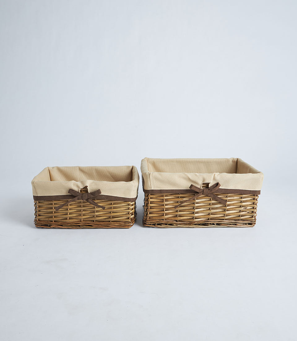 Natural wicker gift baskets with fabric liners and ribbon bows, available in two sizes