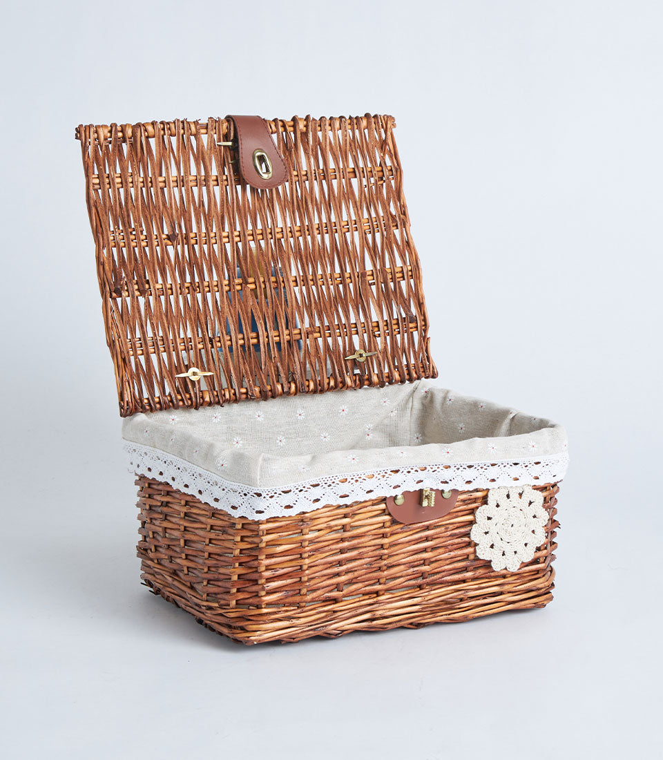 Handwoven rectangular wicker storage basket with hinged lid, natural brown weave, beige floral fabric lining, white lace