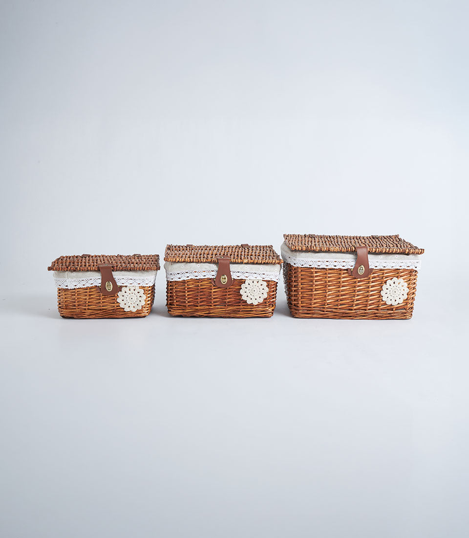 Tiered light woven wicker storage baskets with lace trim and leather closure straps