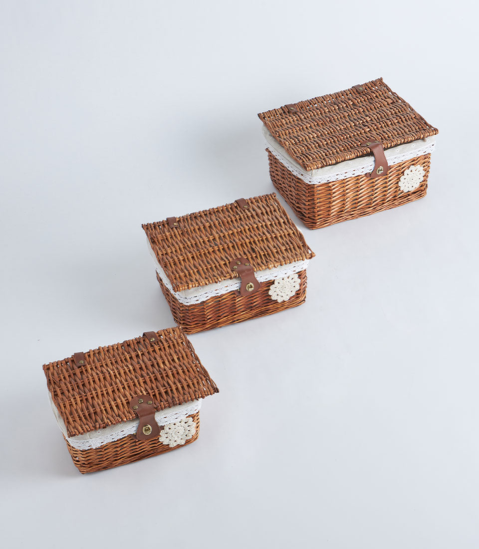 Handwoven rectangular wicker storage baskets with white lace trim and faux leather straps