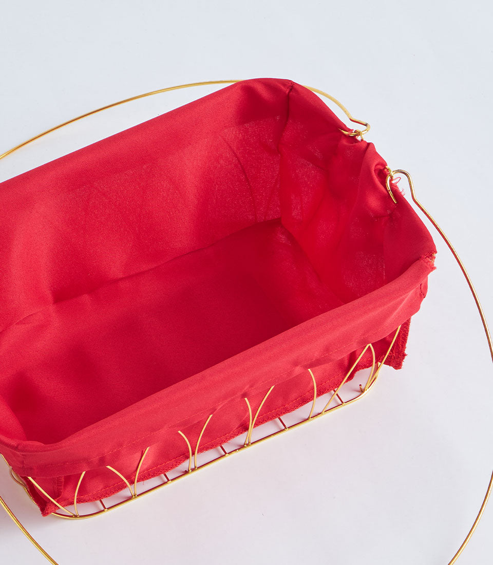 Gold metal wire basket with vibrant red fabric lining and decorative handles