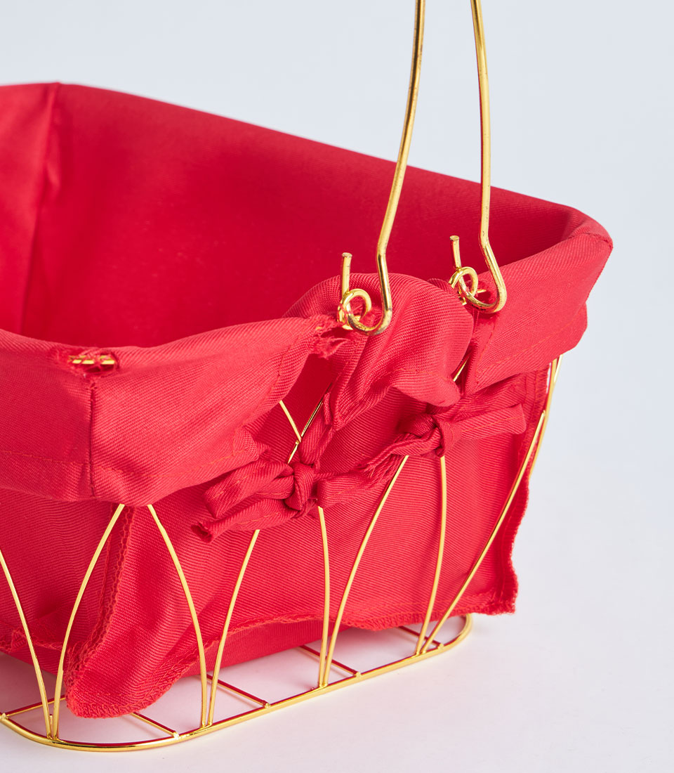 Gold metal wire basket with red fabric lining and decorative bows, festive gift hamper design