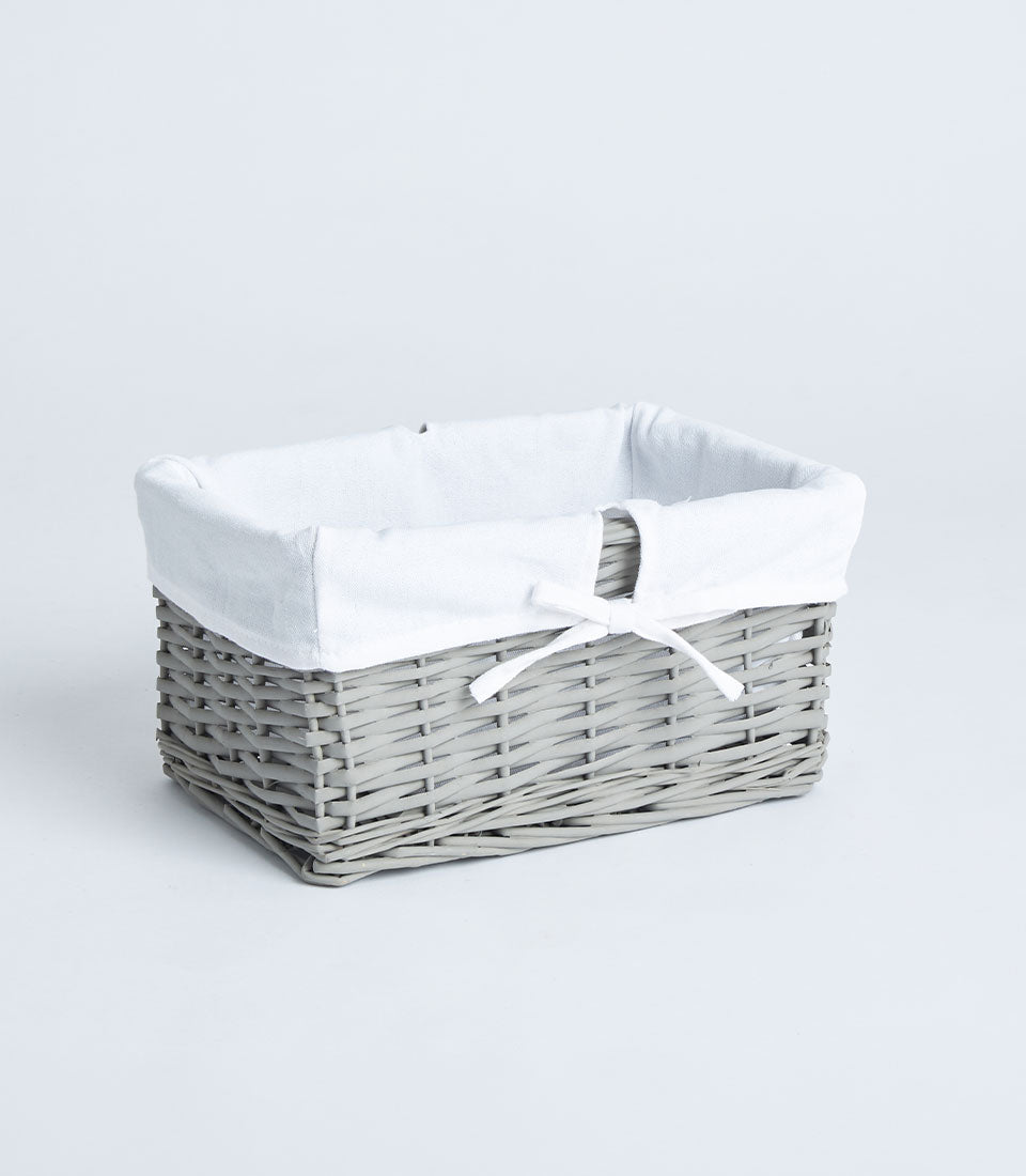 Handwoven light grey wicker basket with white fabric lining and ribbon bow for luxury gifting