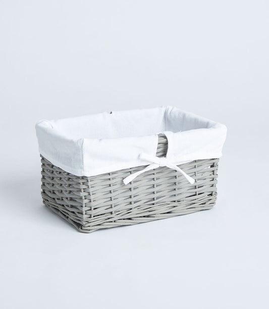 Handwoven light grey wicker basket with white fabric lining and ribbon bow for luxury gifting