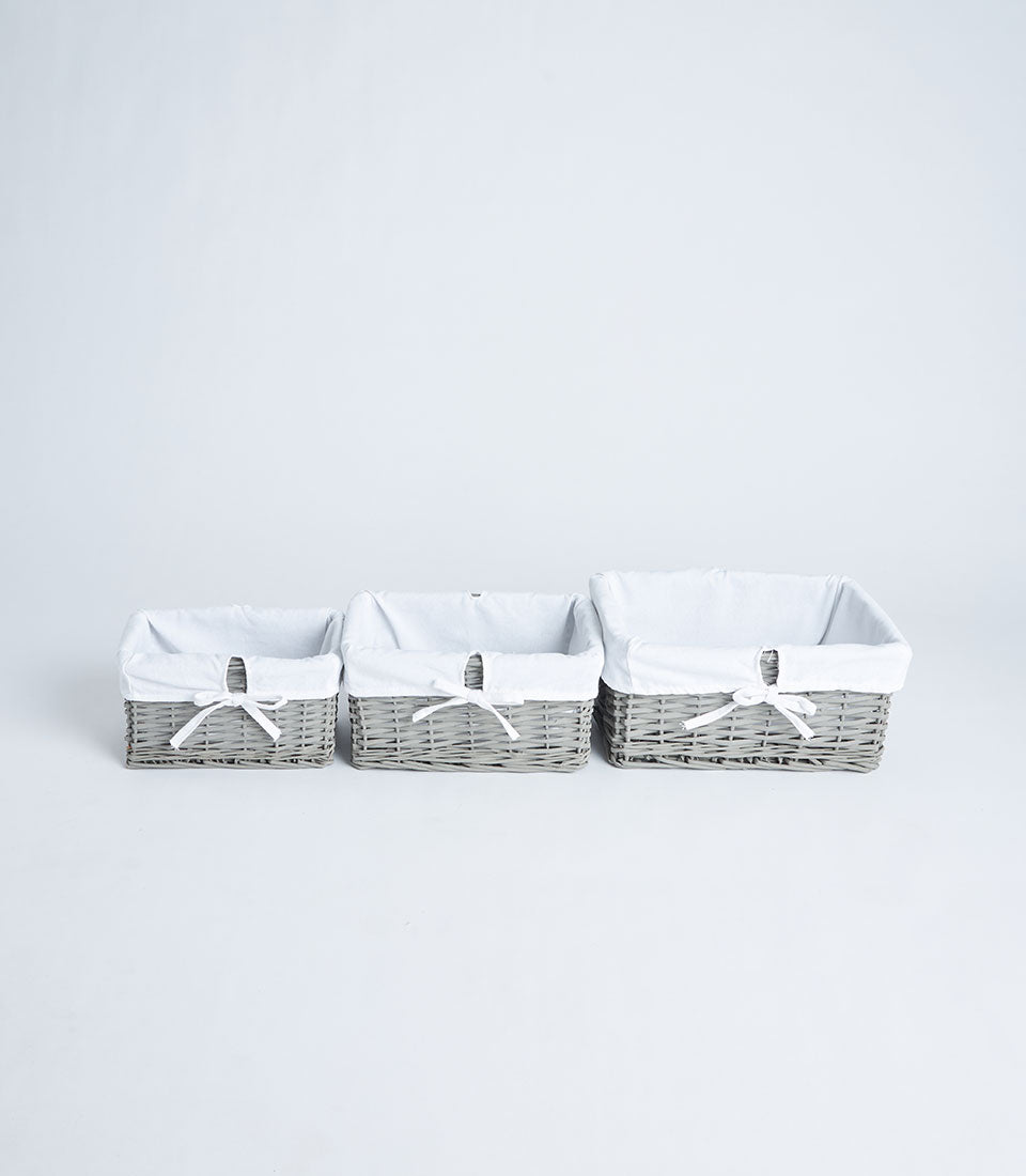 Handwoven grey wicker baskets with white fabric liners in three sizes for gift hampers