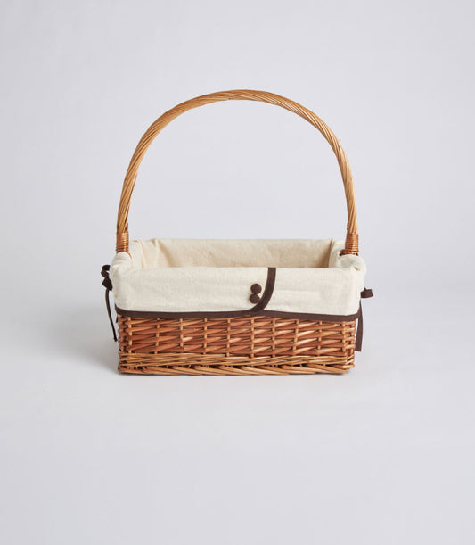 Natural woven rectangular wicker gift basket with cream fabric lining and brown ribbon detail