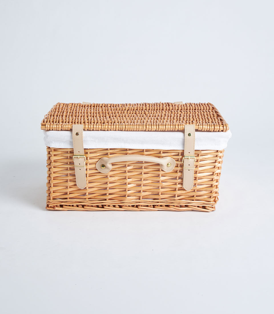 Handwoven rectangular wicker picnic basket with leather straps and hinged lid