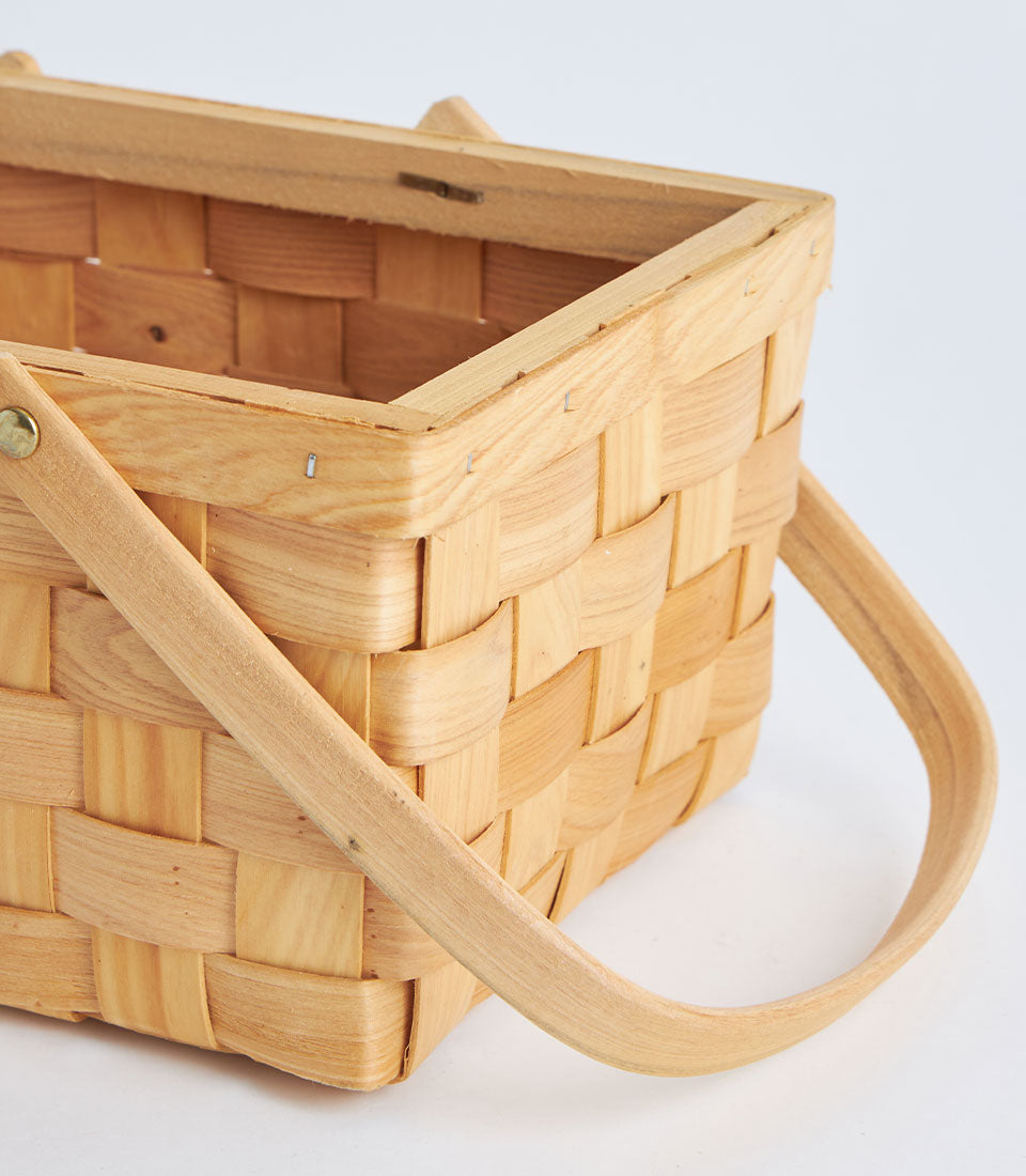 Light wooden rectangular basket with woven bamboo design and dual curved handles for artisan gift presentation