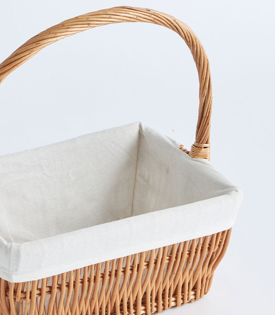 Natural wicker rectangular gift basket with cream linen liner and arched handle
