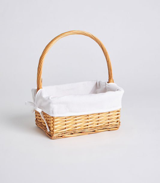 Handwoven light brown wicker gift basket with white fabric liner and arched handle