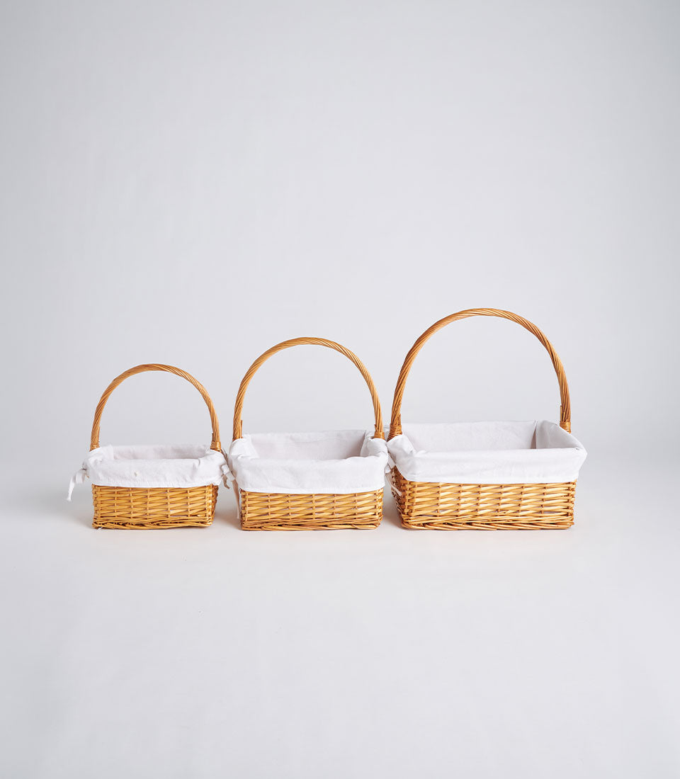 Handwoven rectangular wicker baskets with fabric lining and tall handle in three sizes