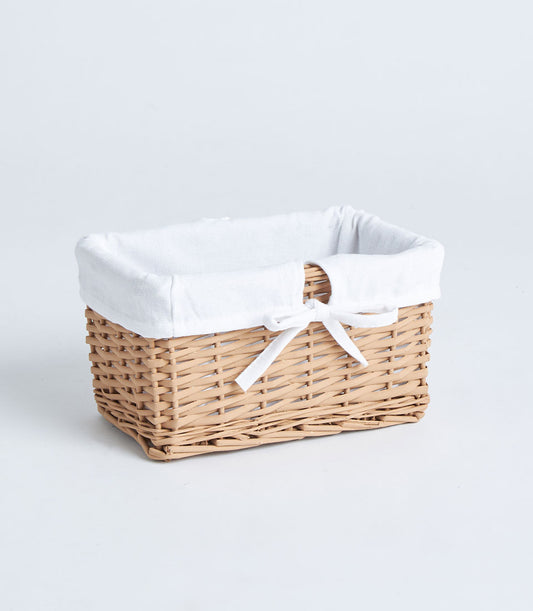 Light brown wicker rectangular basket with white fabric lining and ribbon bow