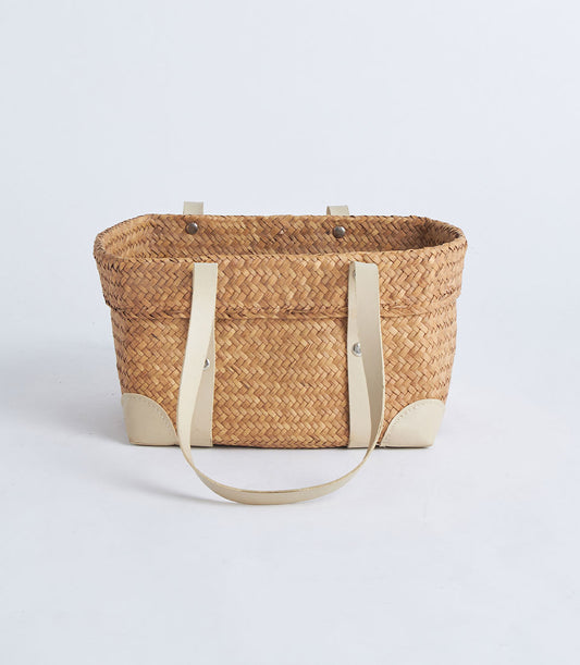 Natural woven straw basket with leather handles and reinforced corners