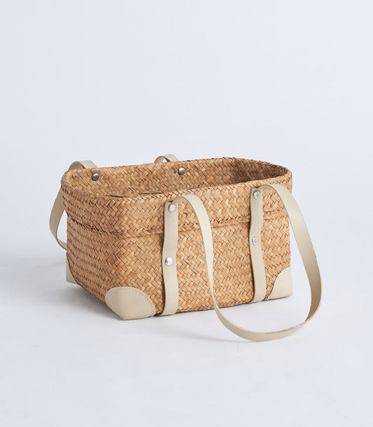 Natural woven straw basket with leather handles and reinforced corners