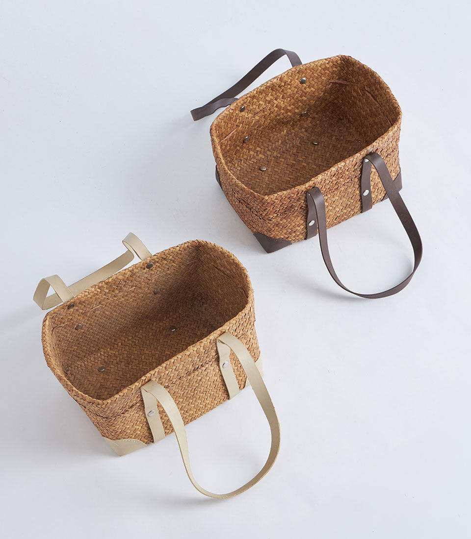 Natural woven oval baskets with leather strap handles, light and dark brown styles for luxury gift hampers