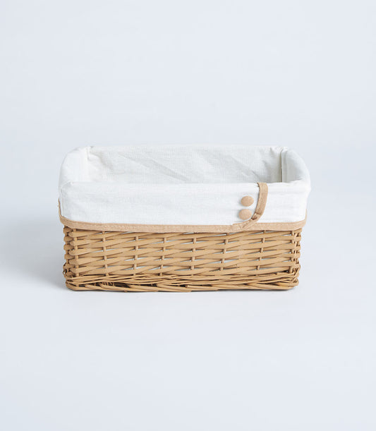 Light brown handwoven wicker basket with white linen liner and jute trim