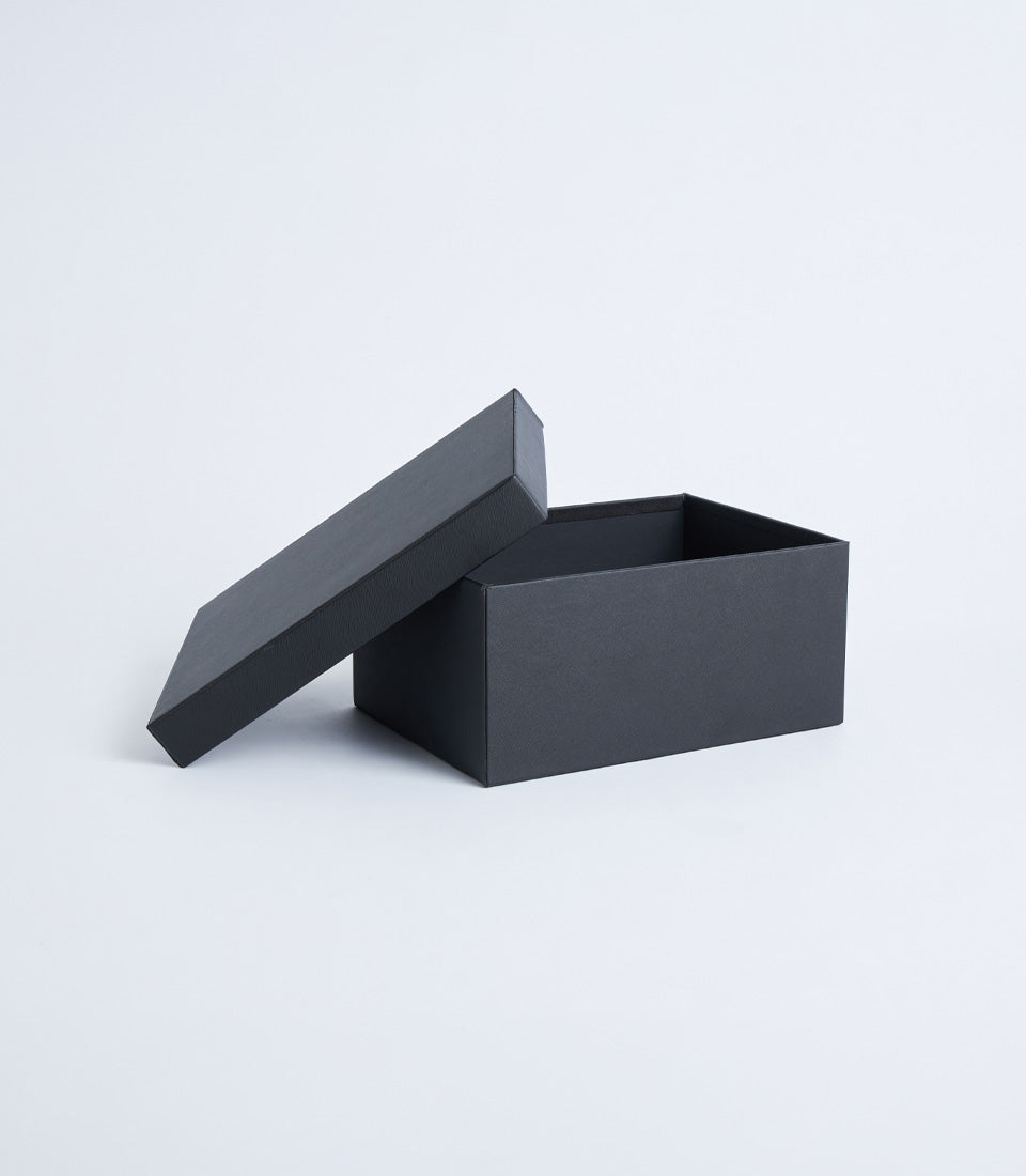Black leather storage box with lid, open to show interior compartment