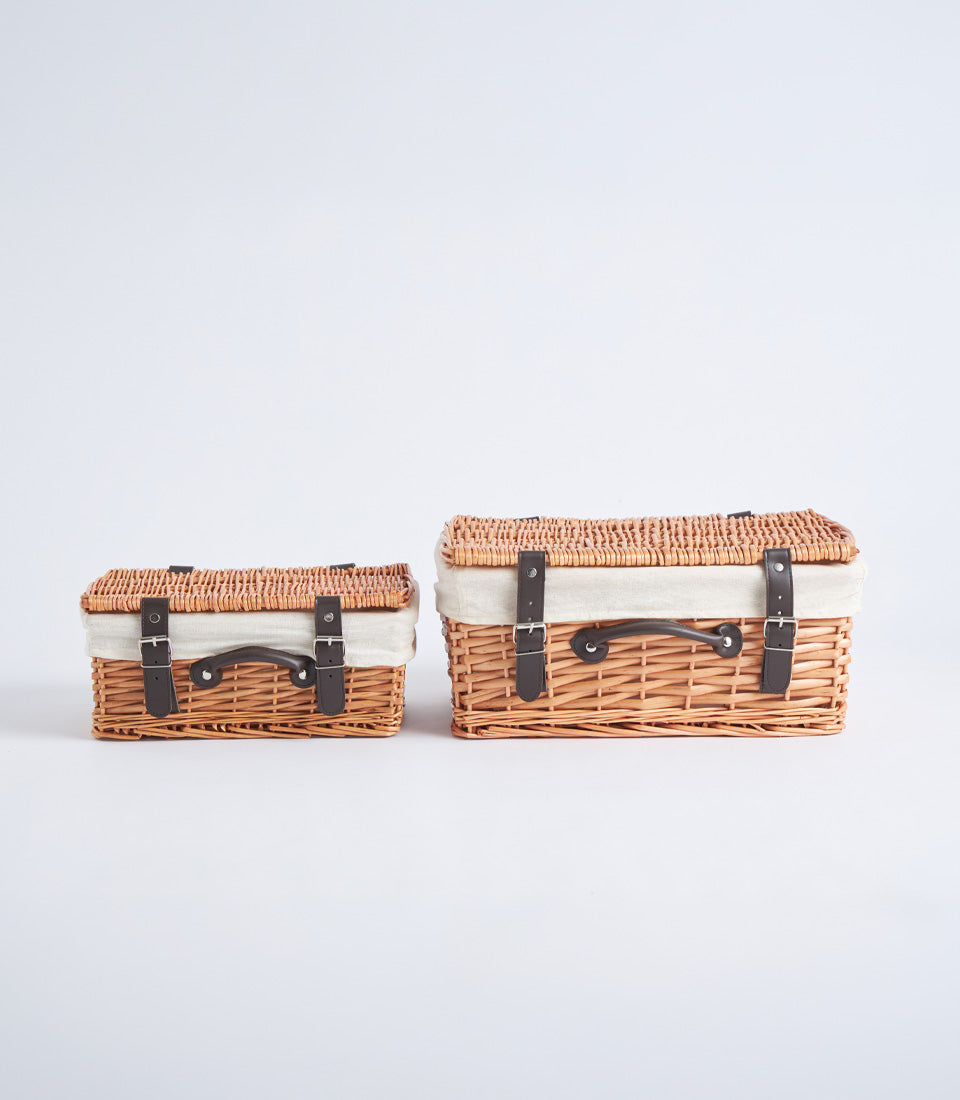 Handwoven wicker picnic baskets with leather straps and cream lining in two sizes
