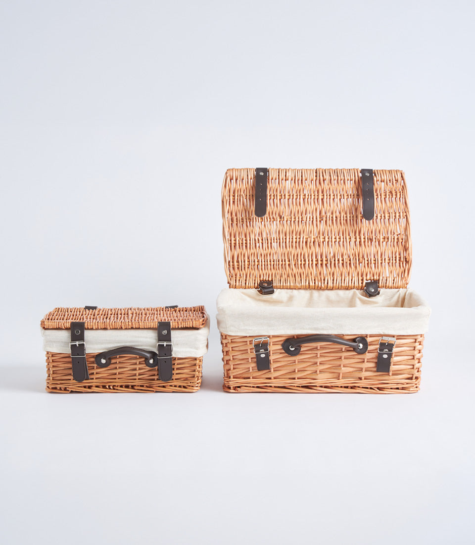 Handwoven wicker picnic baskets with leather straps and fabric lining in light brown