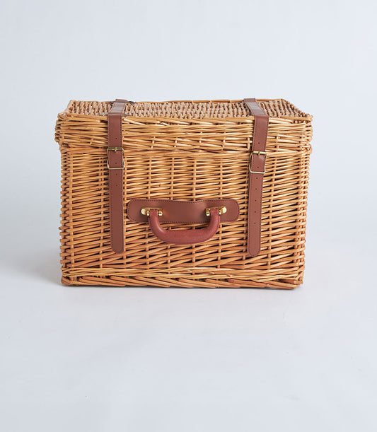 Light brown wicker suitcase basket with dark leather straps and gold buckles for elegant gift giving
