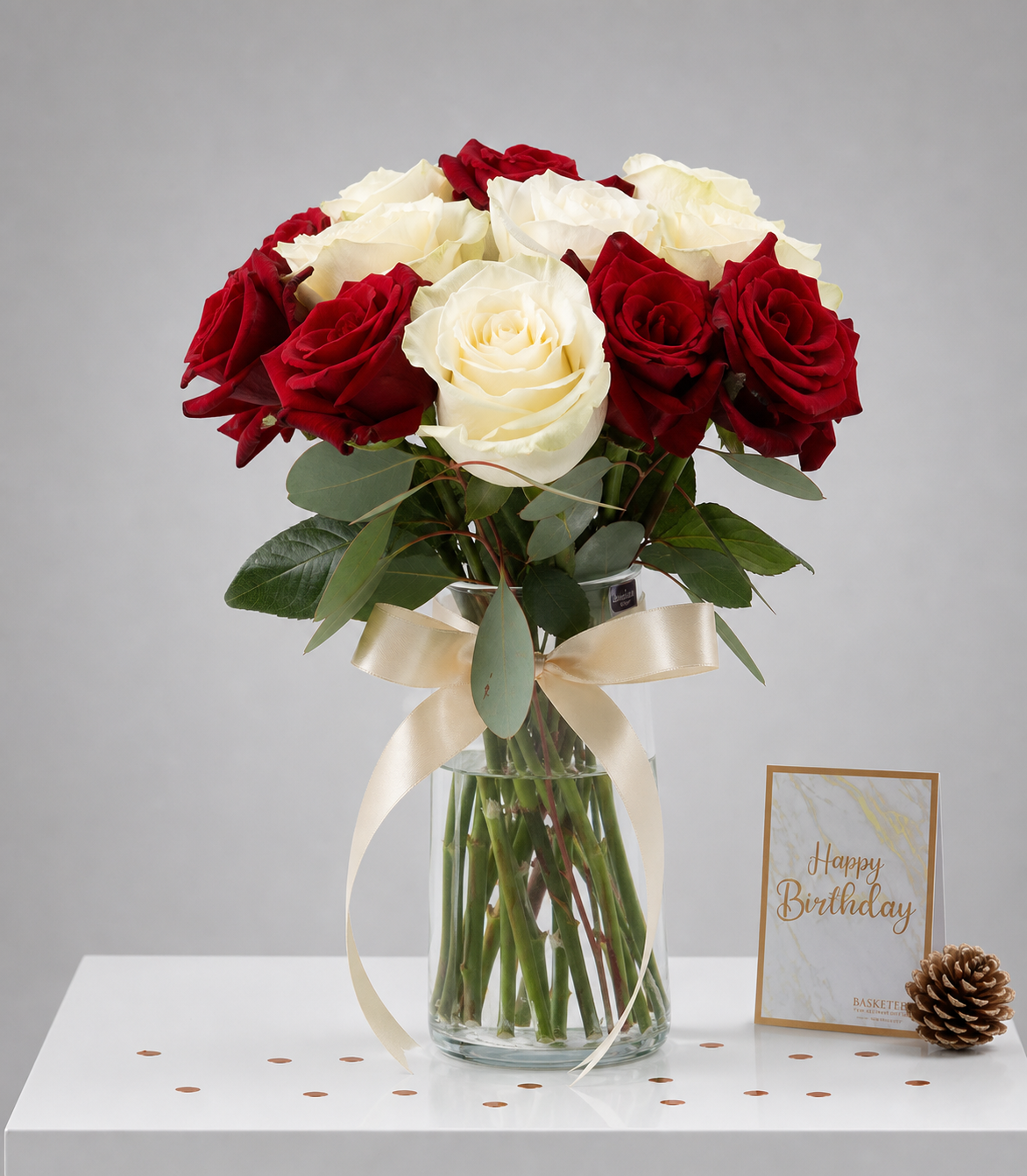Elegant vase arrangement of premium red and white roses with fresh eucalyptus, tied with
