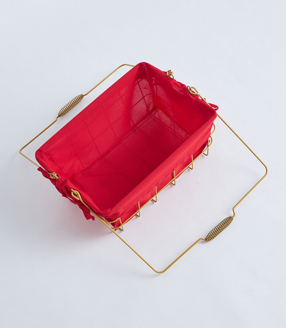 Gold wire metal basket with red fabric lining and decorative handles for gourmet gifts