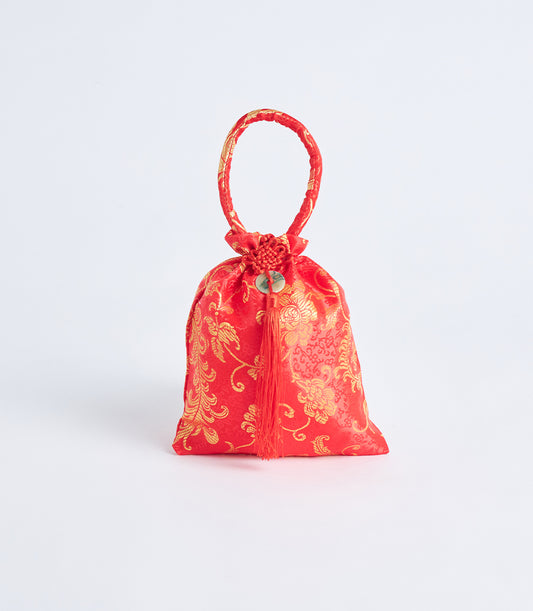 Red silk brocade gift pouch with gold floral pattern, circular handle, and jade charm tassel