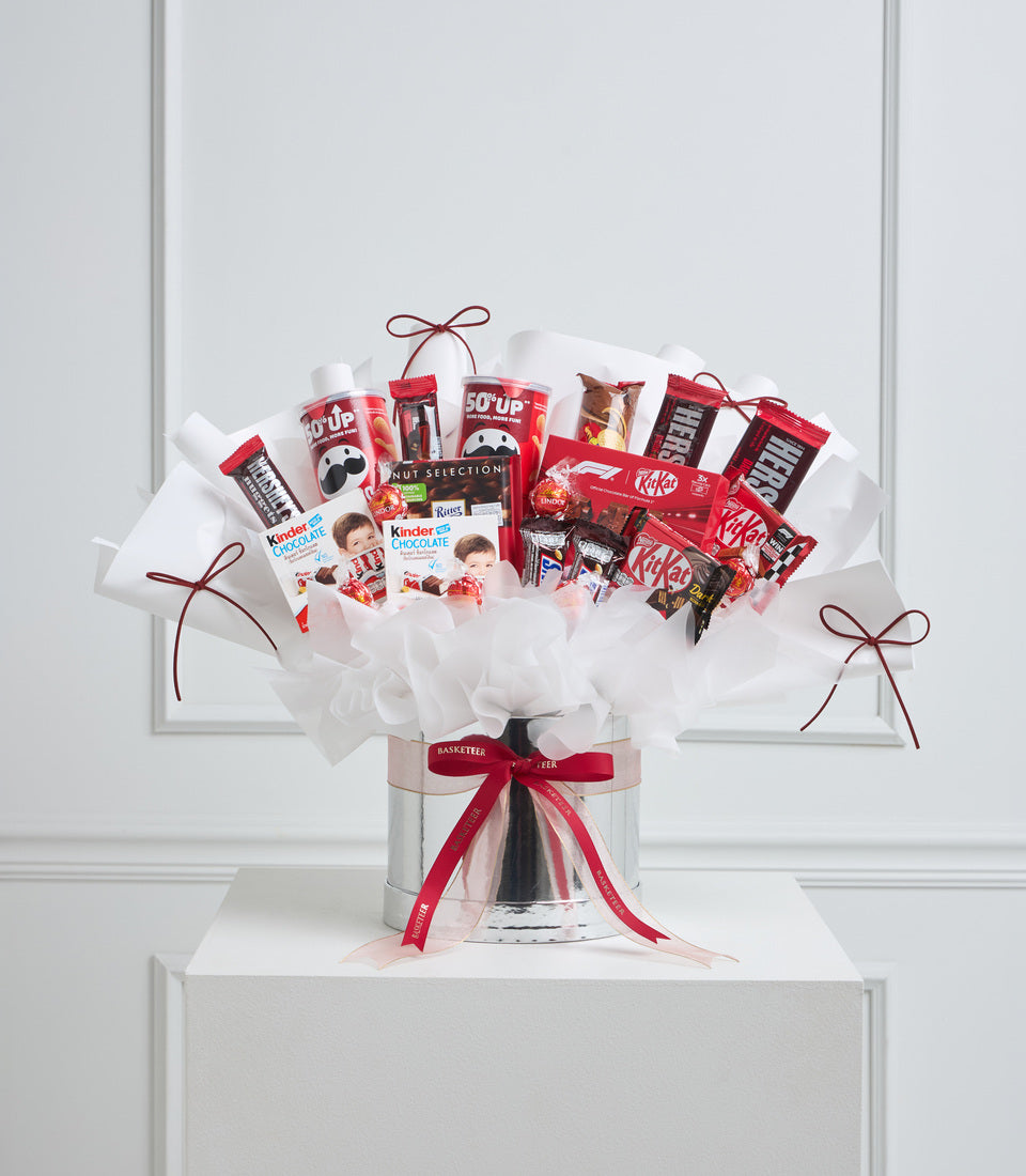 Red and white chocolate gift bouquet with KitKat, Kinder, and assorted sweets in a silver vase with red ribbon bow.