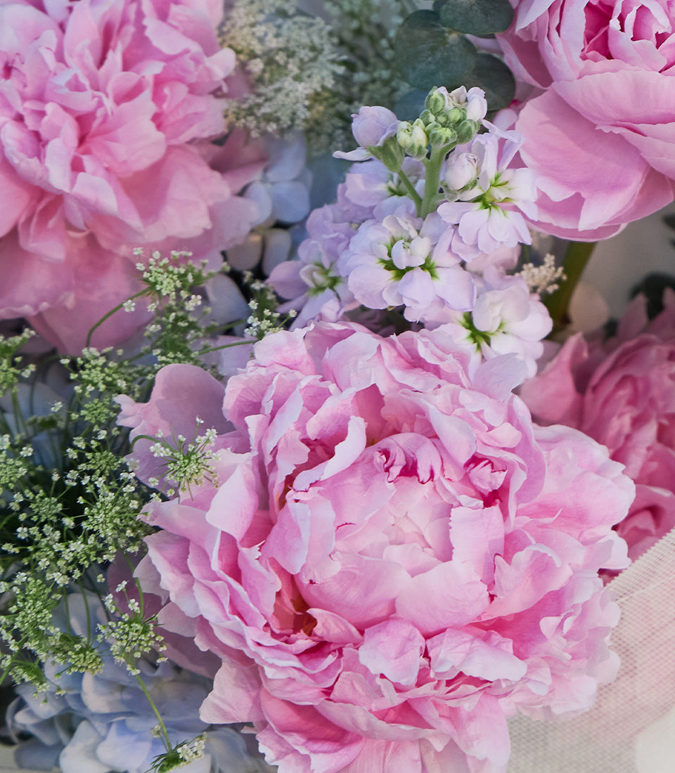 A romantic Flowers by Basketeer bouquet featuring lush pink peonies, soft blue hyd