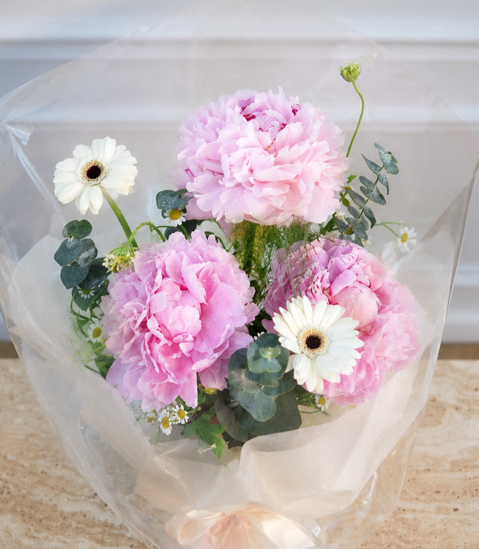 A luxurious Flowers by Basketeer bouquet featuring vibrant pink peonies, fresh