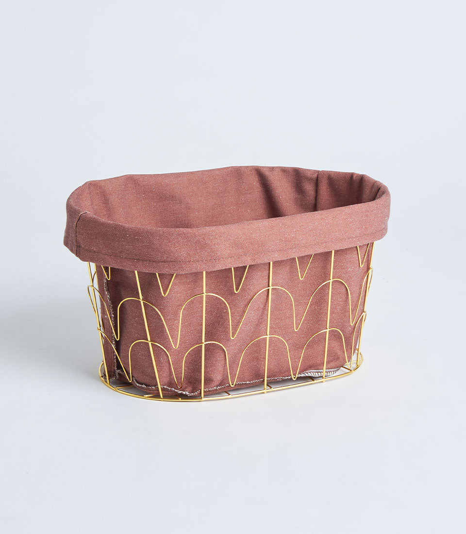 Round metal frame basket with gold handles and dusty rose fabric lining for luxury gift presentation