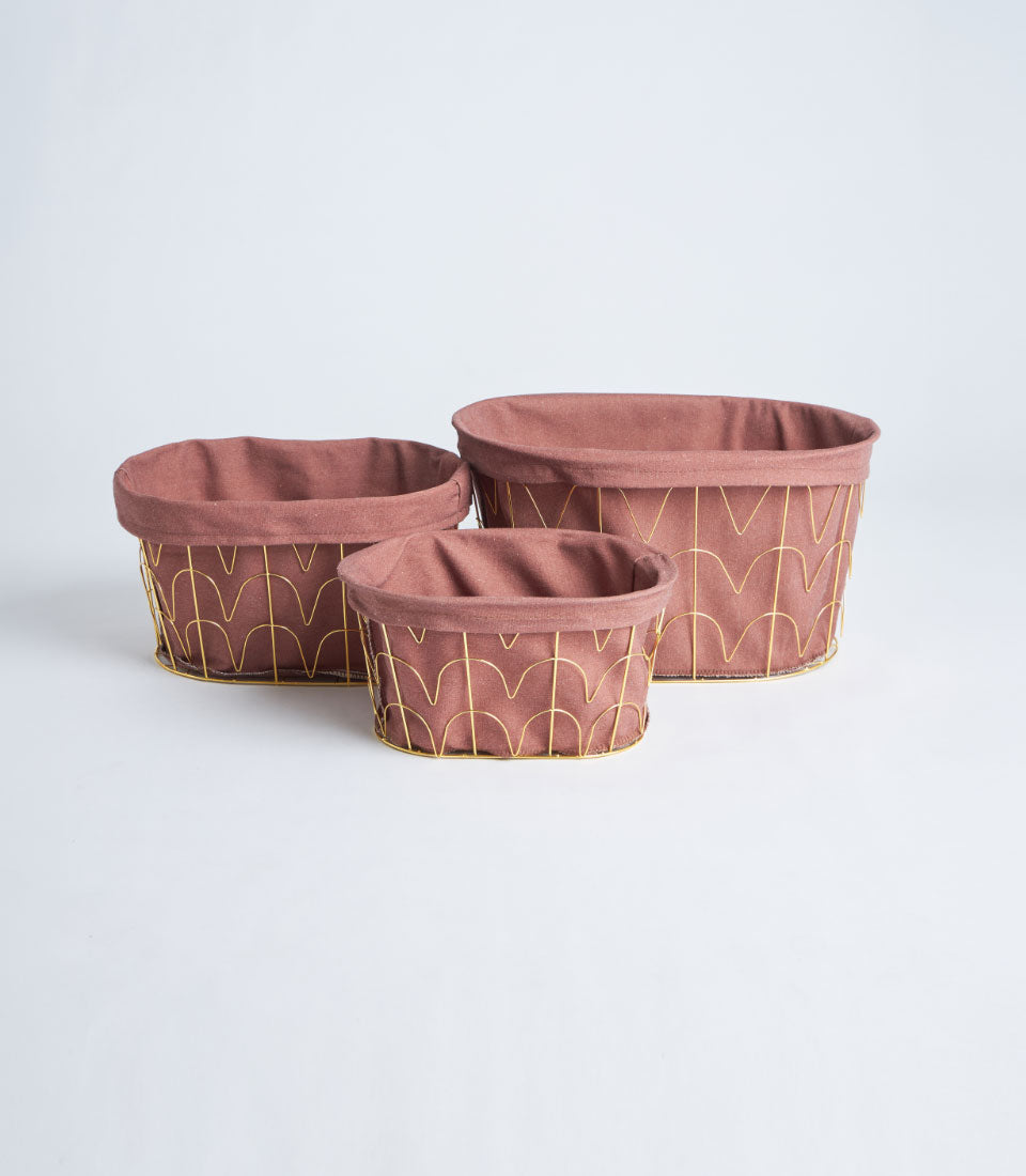 Gold wire storage baskets with dusty rose fabric liners in three sizes
