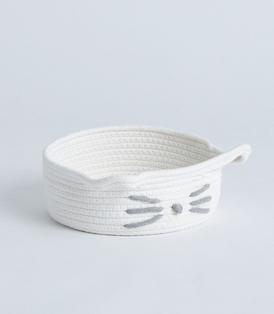White cotton rope storage basket with playful cat face design and handles