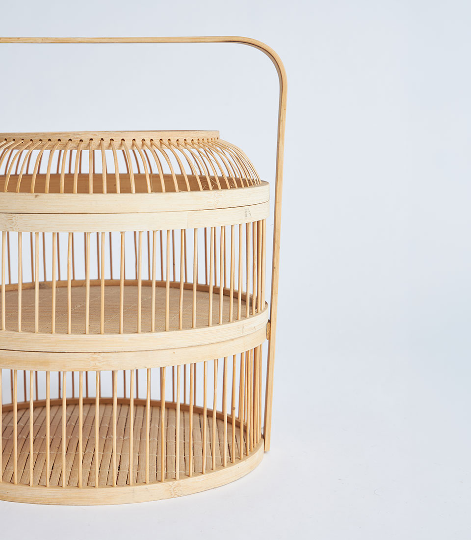 Natural bamboo two-tier display basket with curved handle, light wood artisan craftsmanship