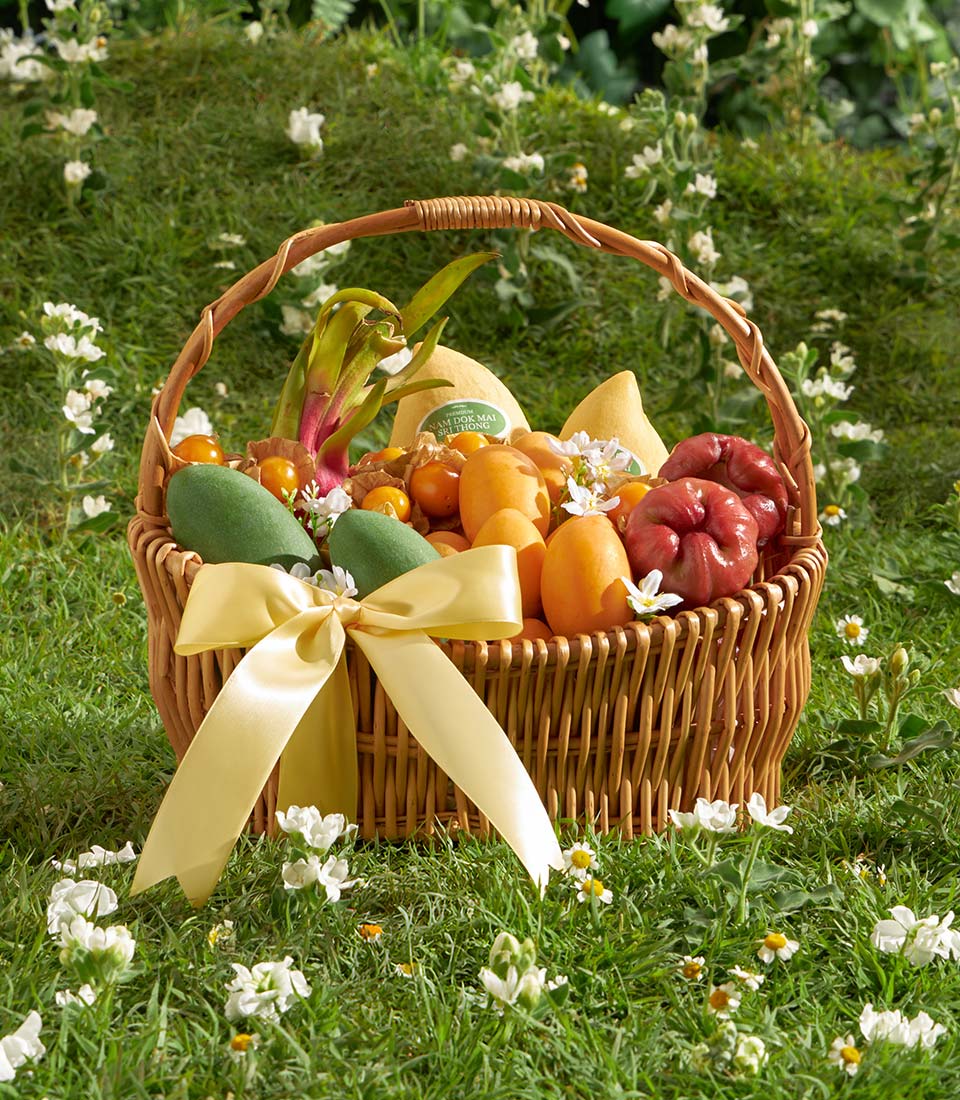 Tropical fruit gift basket with mangoes, dragon fruit, and rose apples tied with yellow satin bow