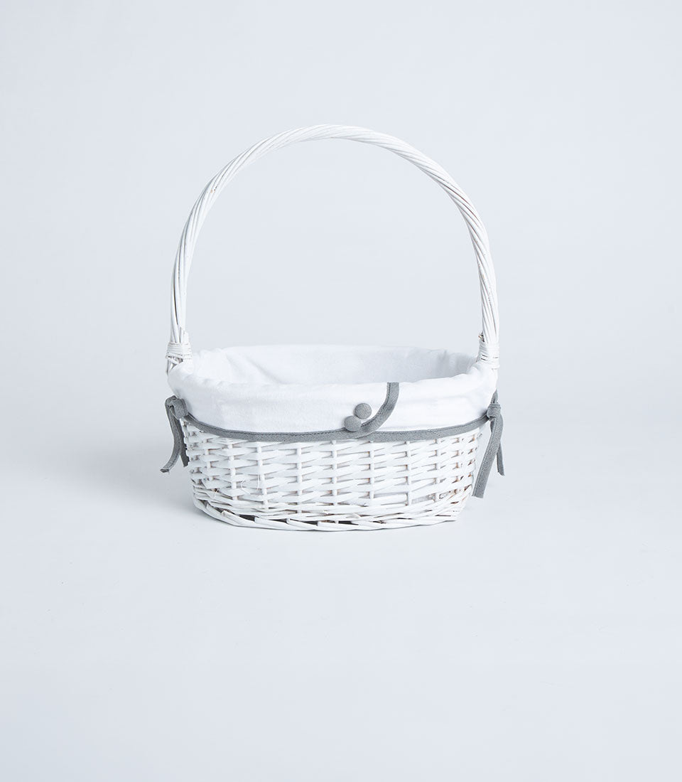Handwoven white wicker basket with tall handle and fabric lining, tied with grey ribbon and decorative buttons