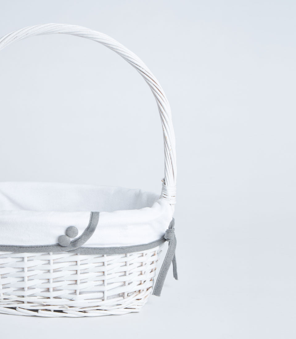 Handwoven white wicker gift basket with tall handle and grey fabric trim detail