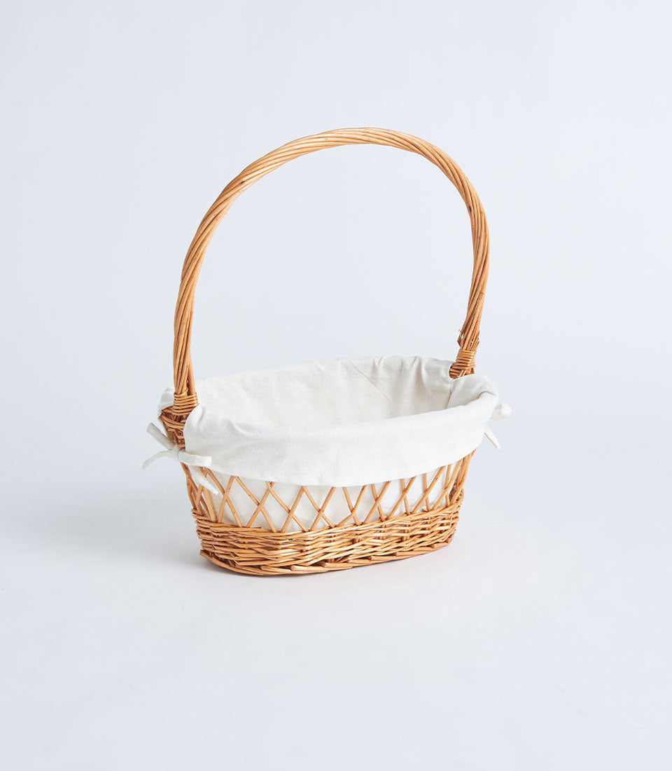 Natural wicker oval basket with lattice weave, white fabric lining, and braided handle