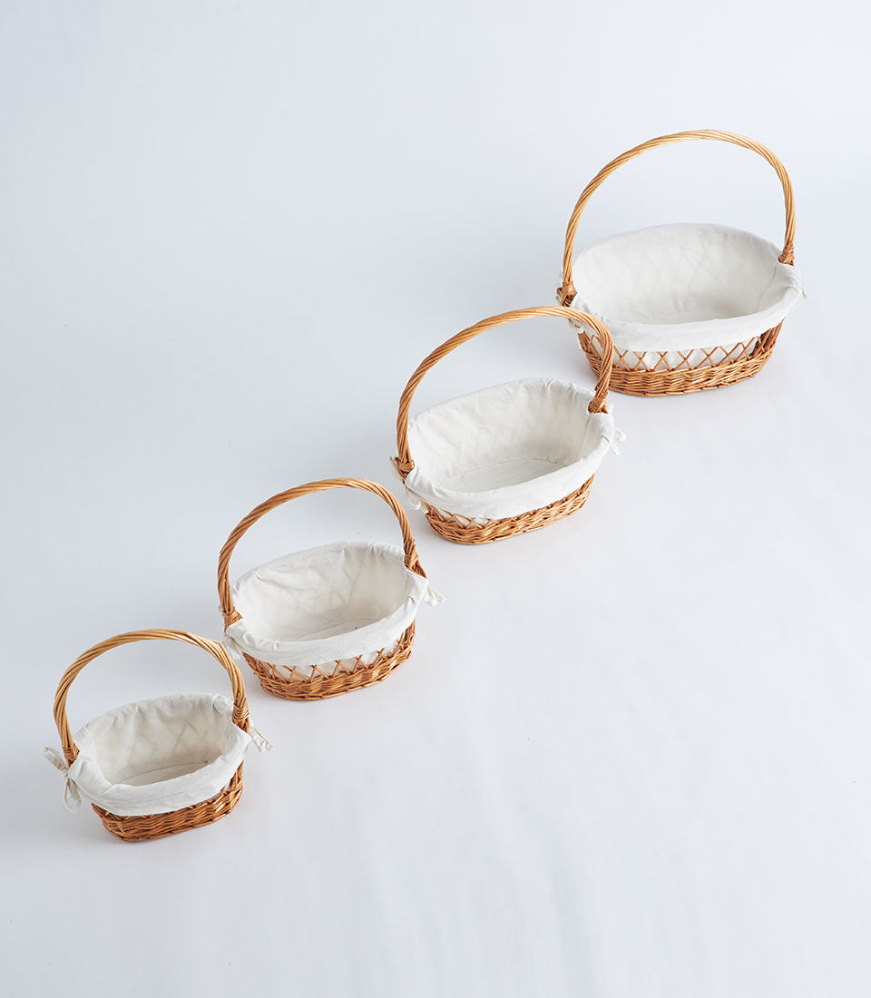 Natural wicker oval baskets with lattice weave, white fabric lining and handles in graduated sizes