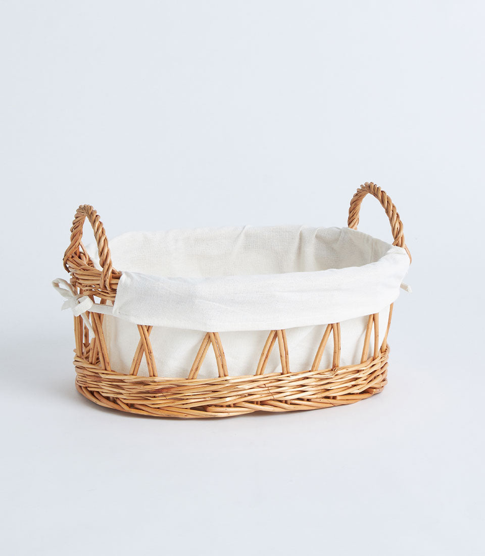 Open weave wicker basket with cream linen lining and braided handles for luxury gift hampers